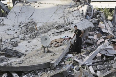 A Palestinian youth inspects the rubble of a destroyed building after it was hit by an Israeli airstrike in Beit Lahiya, northern Gaza Strip.